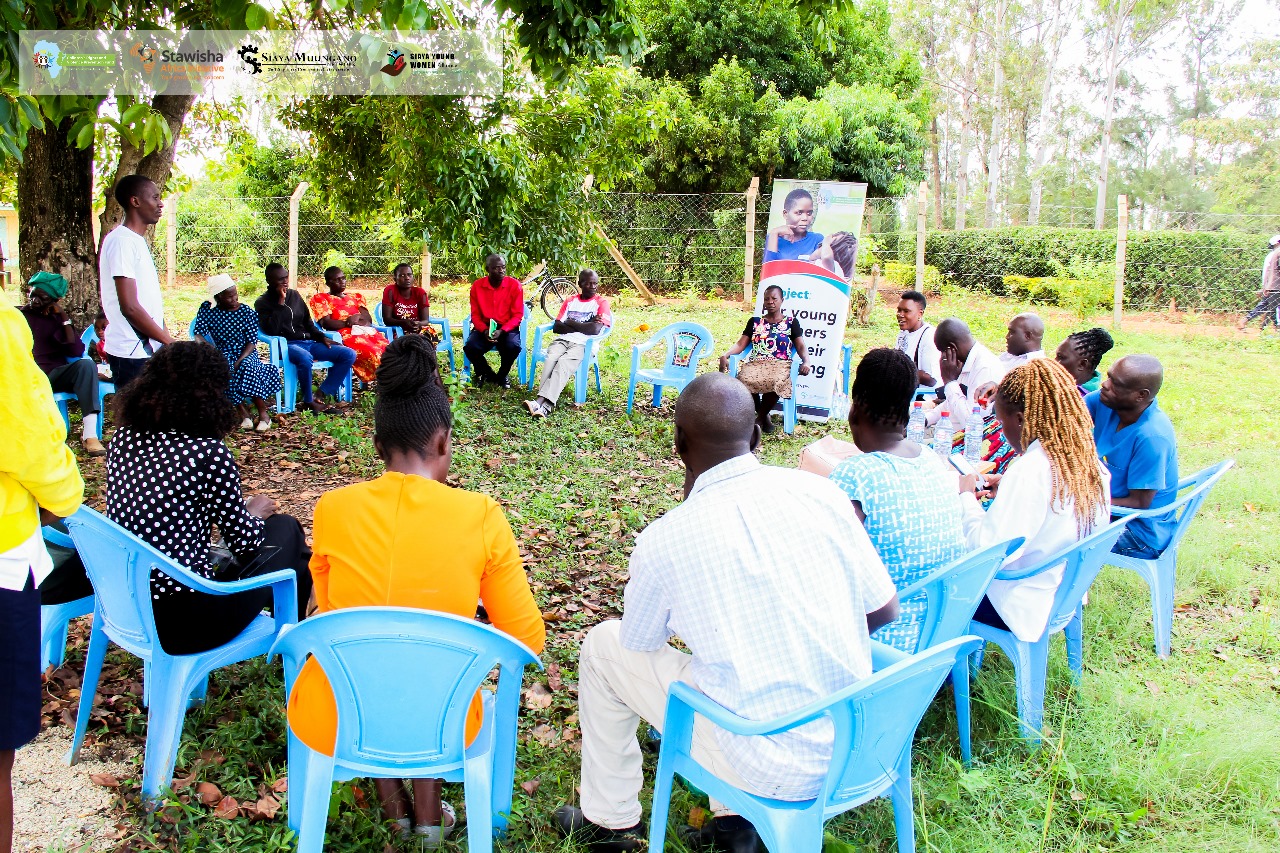Community empowerment meeting showing diverse group of women and youth